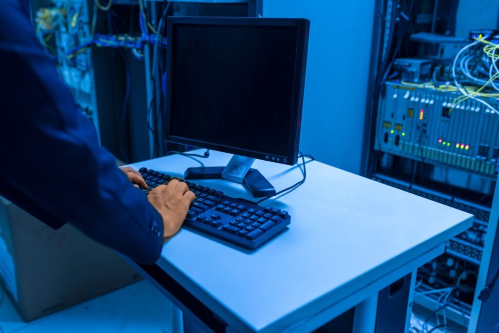 Technicien au clavier devant une baie serveur, diagnostic en cours