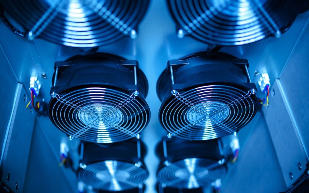 Ventilateurs métalliques de refroidissement vus de près dans un boîtier, éclairage bleuté
