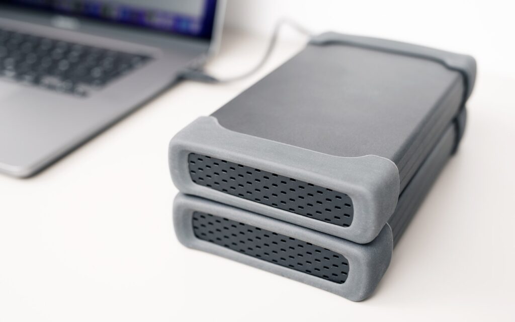 Deux disques durs externes empilés reliés à un ordinateur portable