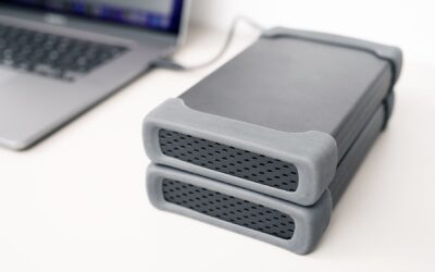 Deux disques durs externes empilés reliés à un ordinateur portable